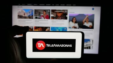 Stuttgart, Almanya - 04-09-2025: Ekvador televizyon kanalı Teleamazonas 'ın logosunun bulunduğu cep telefonu web sayfası önünde. Telefon ekranına odaklan.