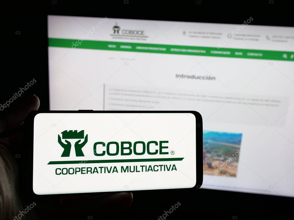Stuttgart, Germany - 04-09-2025: Person holding smartphone with logo of Cooperativa Boliviana de Cemento (COBOCE) on screen in front of website. Focus on phone display.
