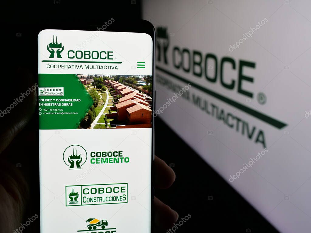 Stuttgart, Germany - 04-09-2025: Person holding cellphone with web page of Cooperativa Boliviana de Cemento (COBOCE) on screen in front of logo. Focus on center of phone display.