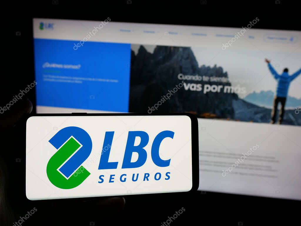 Stuttgart, Germany - 04-09-2025: Person holding smartphone with logo of Bolivian insurance company LBC Seguros on screen in front of website. Focus on phone display.