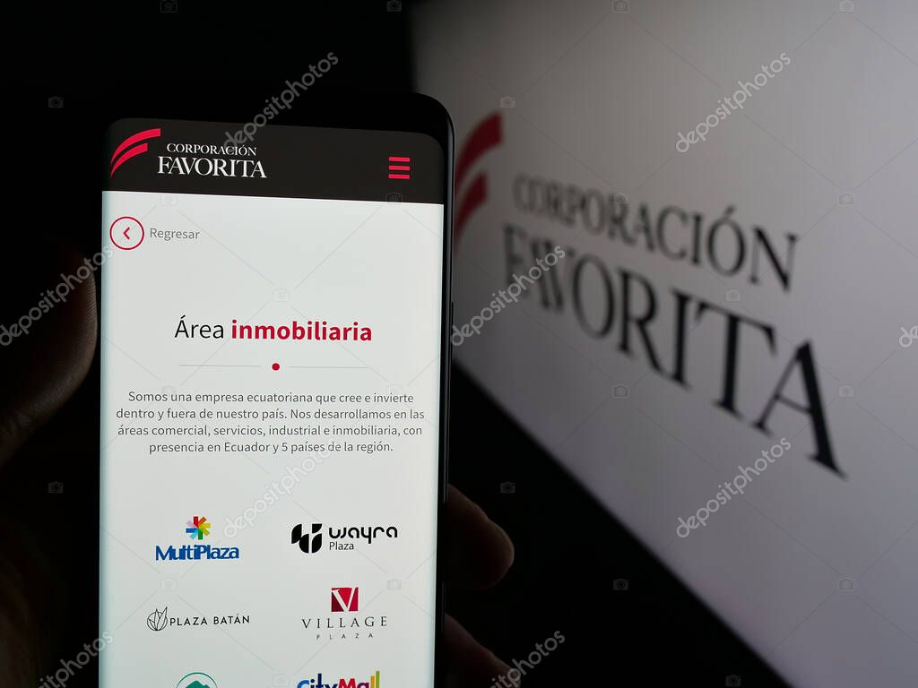 Stuttgart, Germany - 04-09-2025: Person holding smartphone with website of retail company Corporacion Favorita C.A. on screen in front of logo. Focus on center of phone display.
