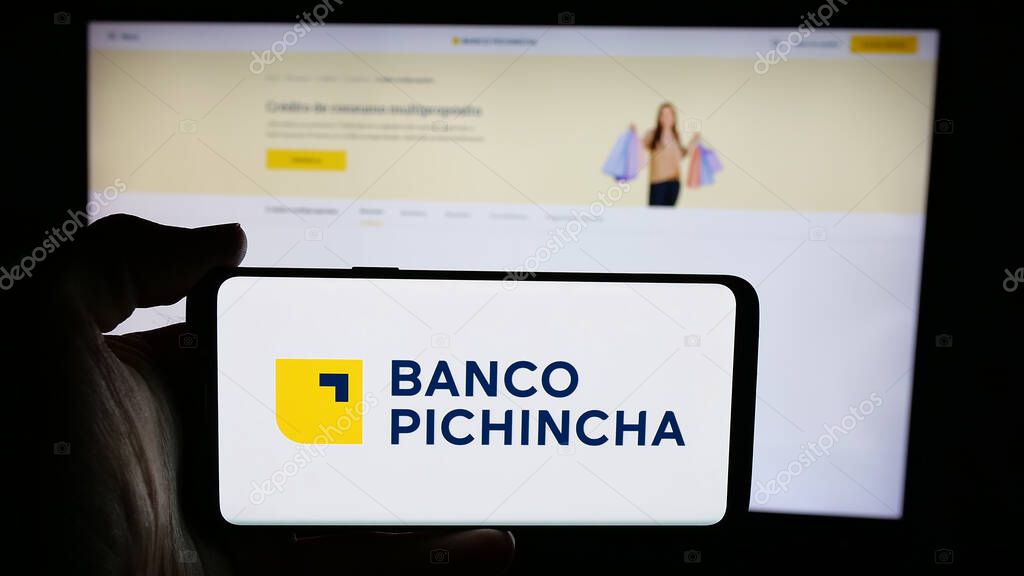 Stuttgart, Germany - 04-09-2025: Person holding cellphone with logo of financial company Banco Pichincha C.A. on screen in front of webpage. Focus on phone display.