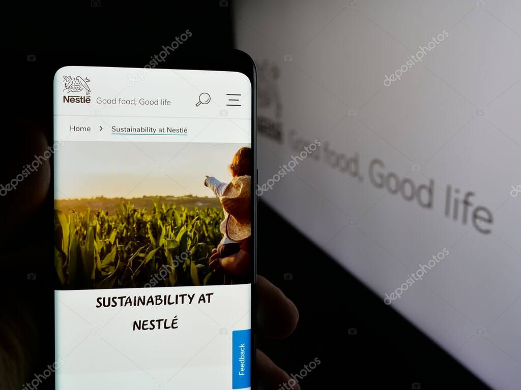 Stuttgart, Germany - 04-09-2025: Person holding cellphone with web page of Swiss food and beverage company Nestle S.A. on screen in front of logo. Focus on center of phone display.