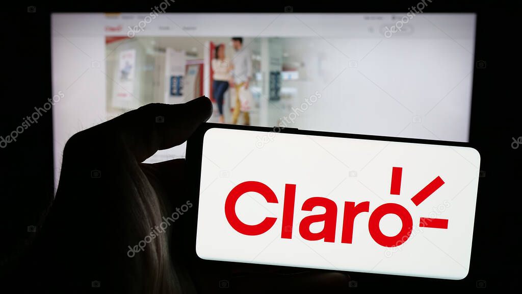 Stuttgart, Germany - 04-09-2025: Person holding mobile phone with logo of telecommunications company Claro Ecuado on screen in front of web page. Focus on phone display.