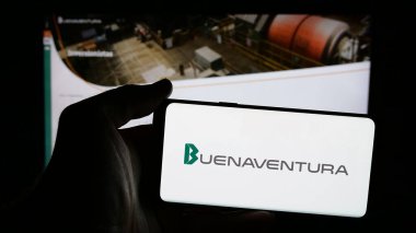 Stuttgart, Almanya - 04-09-2025: Compania de Minas Buenaventura S.A.A. şirketinin logosuna sahip cep telefonu sahibi kişi Web sayfasının önünde ekranda. Telefon ekranına odaklan.