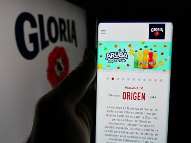 Stuttgart, Almanya - 04-09-2025: Perulu mandıra şirketi Gloria S.A. 'nın web sitesi ile akıllı telefon taşıyan kişi logonun önünde ekranda. Telefon ekranının merkezine odaklan.