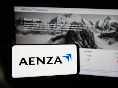 Stuttgart, Almanya - 04-09-2025: Perulu emlak şirketi Aenza S.A.A. 'nın logosuna sahip akıllı telefon sahibi kişi Web sitesinin önünde ekranda. Telefon ekranına odaklan.