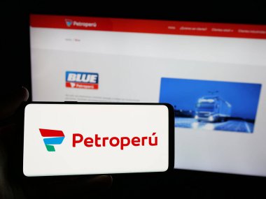 Stuttgart, Almanya - 04-09-2025: İnternet sitesi önünde Petroleos del Peru S.A. (Petroperu) şirketinin logosuna sahip akıllı telefon sahibi kişi. Telefon ekranına odaklan.