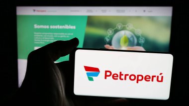 Stuttgart, Almanya - 04-09-2025: Web sayfası önünde Petroleos del Peru S.A. (Petroperu) şirketinin logosunun bulunduğu cep telefonu sahibi kişi. Telefon ekranına odaklan.