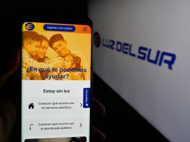 Stuttgart, Almanya - 04-17-2025: Perulu enerji şirketi Luz del Sur S.A.A. 'nın internet sitesi ile akıllı telefon sahibi olan kişi Ekranda logonun önünde. Telefon ekranının merkezine odaklan.