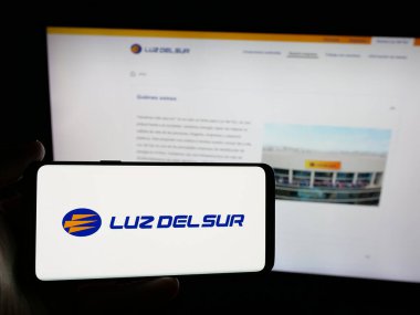 Stuttgart, Almanya - 04-17-2025: Perulu enerji şirketi Luz del Sur S.A.A. 'nın logosunu taşıyan kişi Web sitesinin önünde ekranda. Telefon ekranına odaklan.