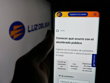 Stuttgart, Almanya - 04-17-2025: Perulu enerji şirketi Luz del Sur S.A.A. 'nın internet sayfası ile cep telefonu tutan kişi Ekranda logonun önünde. Telefon ekranının merkezine odaklan.