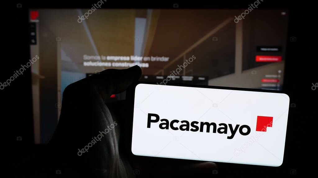 Stuttgart, Germany - 04-09-2025: Person holding mobile phone with logo of Peruvian company Cementos Pacasmayo S.A.A. on screen in front of web page. Focus on phone display.
