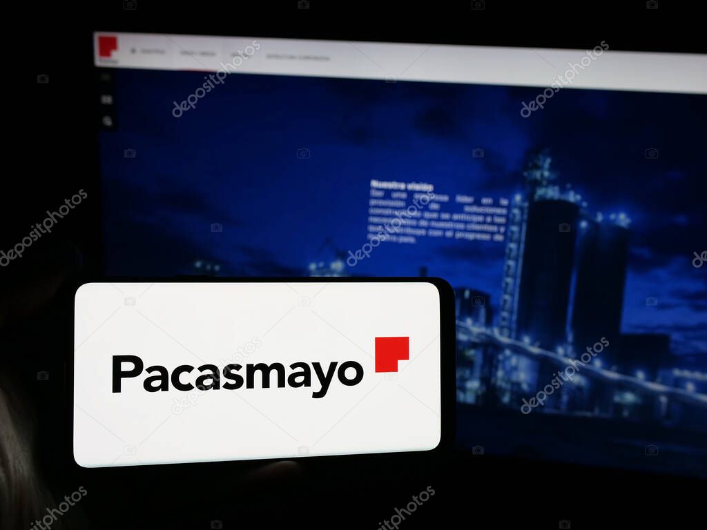 Stuttgart, Germany - 04-09-2025: Person holding smartphone with logo of Peruvian company Cementos Pacasmayo S.A.A. on screen in front of website. Focus on phone display.