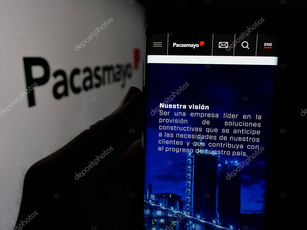 Stuttgart, Germany - 04-09-2025: Person holding smartphone with website of Peruvian company Cementos Pacasmayo S.A.A. on screen in front of logo. Focus on center of phone display.