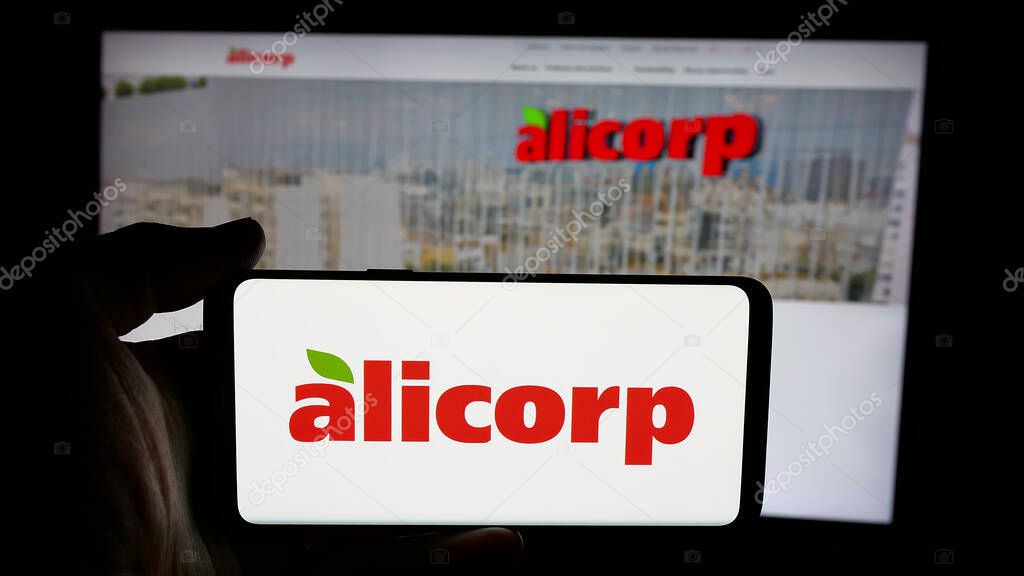 Stuttgart, Germany - 04-09-2025: Person holding cellphone with logo of consumer goods company Alicorp S.A.A. (Peru) on screen in front of webpage. Focus on phone display.