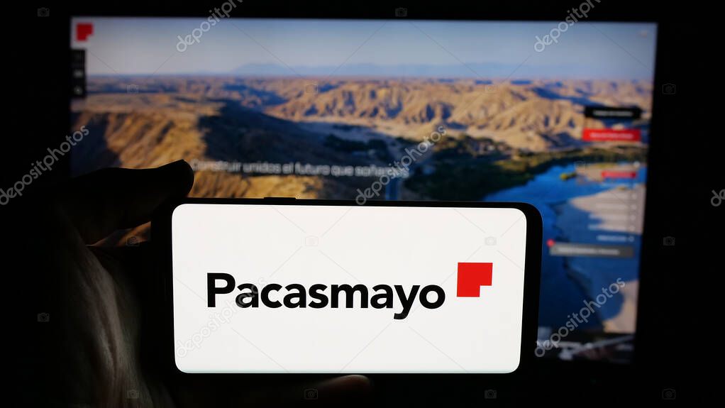 Stuttgart, Germany - 04-09-2025: Person holding cellphone with logo of Peruvian company Cementos Pacasmayo S.A.A. on screen in front of webpage. Focus on phone display.