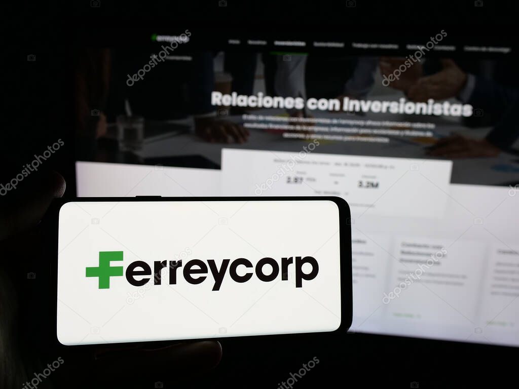 Stuttgart, Germany - 04-17-2025: Person holding smartphone with logo of Peruvian machinery company Ferreycorp S.A.A. on screen in front of website. Focus on phone display.