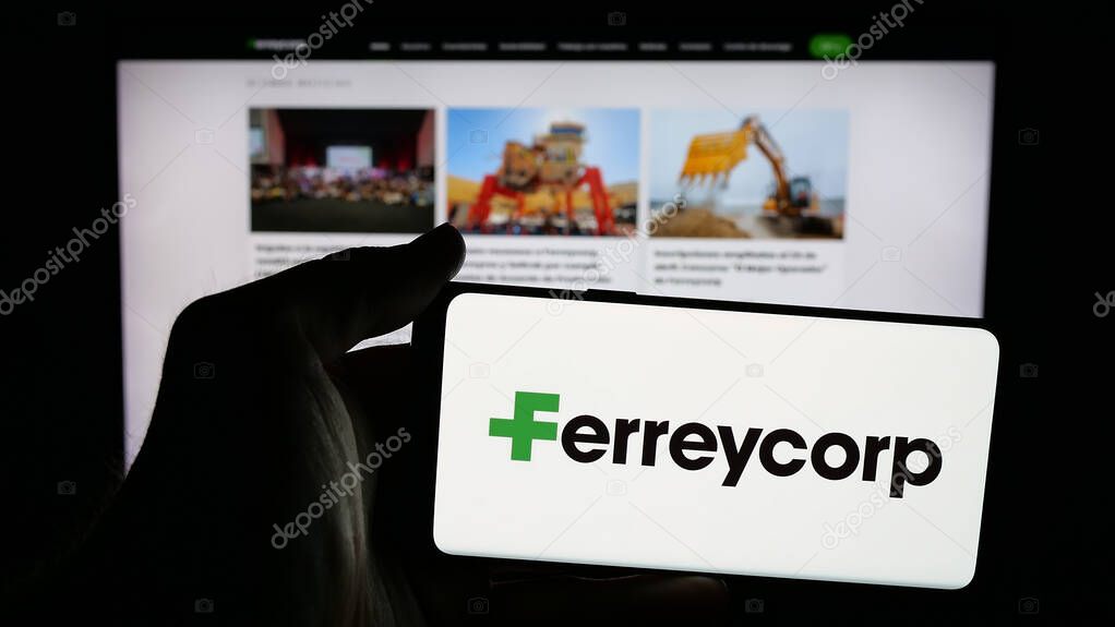 Stuttgart, Germany - 04-17-2025: Person holding mobile phone with logo of Peruvian machinery company Ferreycorp S.A.A. on screen in front of web page. Focus on phone display.