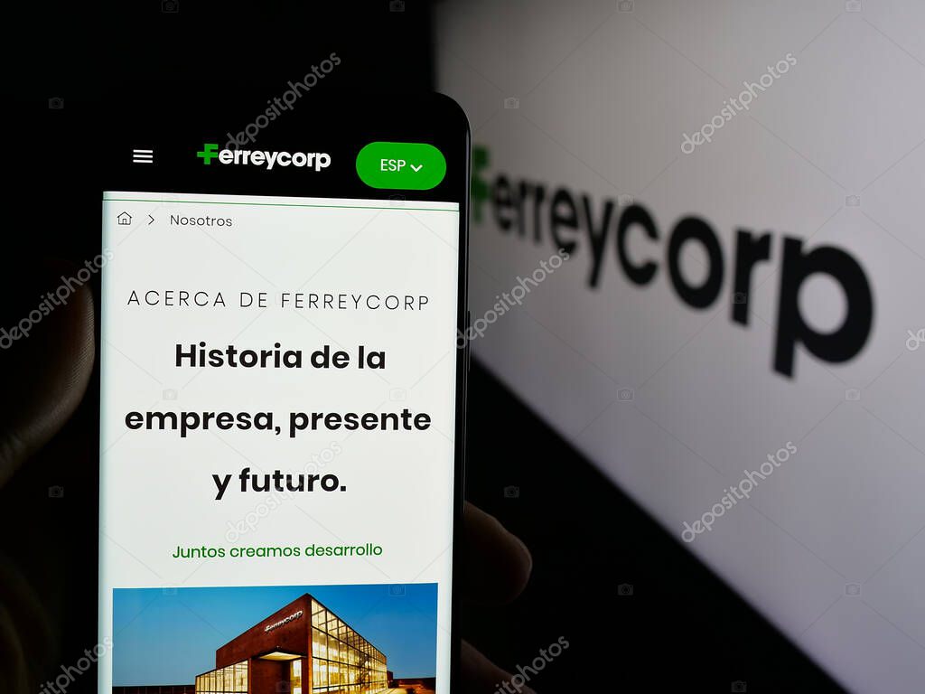 Stuttgart, Germany - 04-17-2025: Person holding smartphone with website of Peruvian machinery company Ferreycorp S.A.A. on screen in front of logo. Focus on center of phone display.