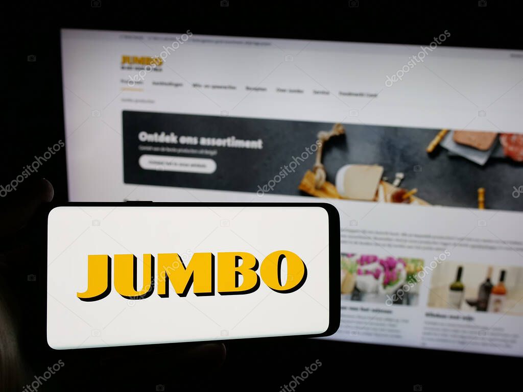 Stuttgart, Germany - 04-17-2025: Person holding smartphone with logo of Dutch company Koninklijke Jumbo Food Groep on screen in front of website. Focus on phone display.