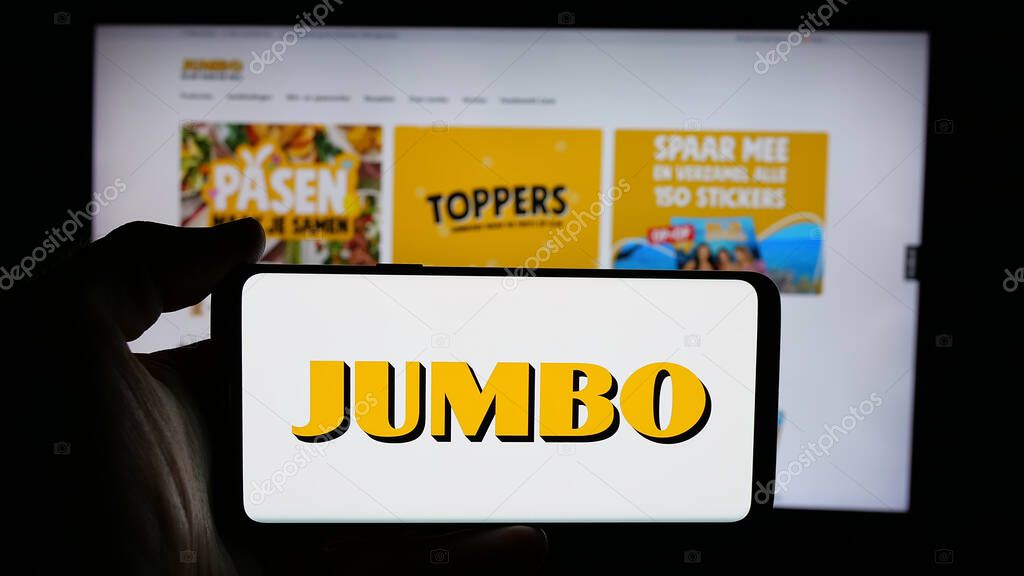 Stuttgart, Germany - 04-17-2025: Person holding cellphone with logo of Dutch company Koninklijke Jumbo Food Groep on screen in front of webpage. Focus on phone display.