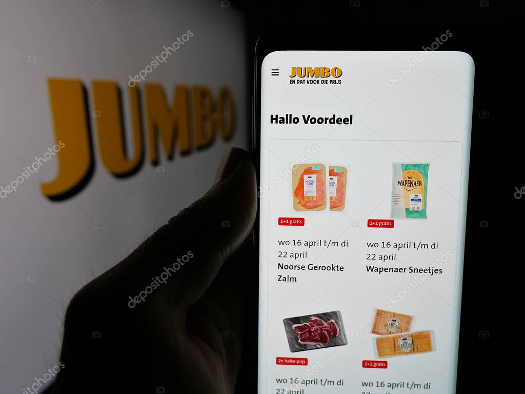 Stuttgart, Germany - 04-17-2025: Person holding cellphone with web page of Dutch company Koninklijke Jumbo Food Groep on screen in front of logo. Focus on center of phone display.