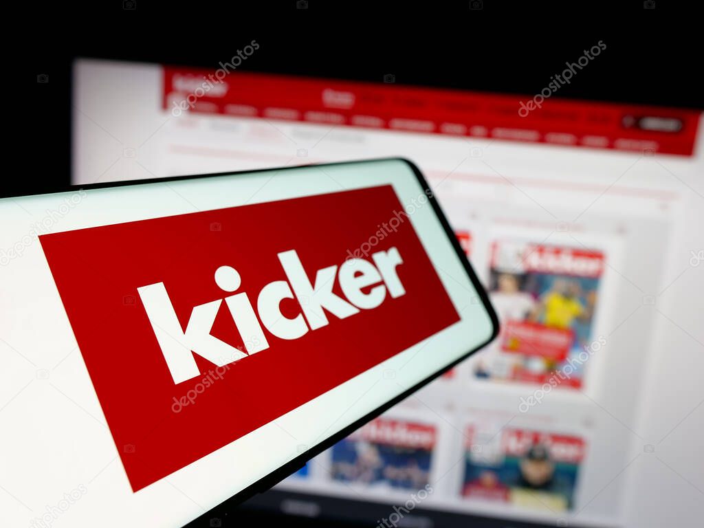 Stuttgart, Germany - 04-17-2025: Smartphone with logo of German football and sports magazine Kicker on screen in front of website. Focus on center-left of phone display.