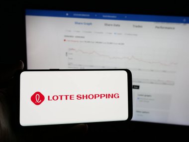 Stuttgart, Almanya - 04-24-2025: Perakende şirketi Lotte Shopping Co. Ltd. nin logosuna sahip akıllı telefon sahibi kişi web sitesinin önünde ekranda. Telefon ekranına odaklan.