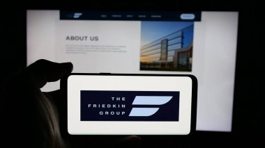 Stuttgart, Almanya - 04-24-2025: ABD 'li şirket The Friedkin Group' un logosunun bulunduğu cep telefonu web sayfası önünde ekranda. Telefon ekranına odaklan.