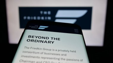 Stuttgart, Almanya - 04-24-2025: ABD 'li şirket The Friedkin Group' un web sayfası logo önünde ekranda. Telefon ekranının sol üst kısmına odaklan.