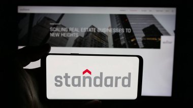 Stuttgart, Almanya - 04-24-2025: ABD 'li Standard Industries Inc. şirketinin logosunun bulunduğu cep telefonu web sayfası önünde ekranda. Telefon ekranına odaklan.
