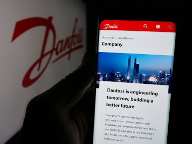 Stuttgart, Almanya - 04-24-2025: Danimarkalı HVAC şirketi Danfoss AS 'in web sayfası olan cep telefonu logosu önünde ekranda. Telefon ekranının merkezine odaklan.