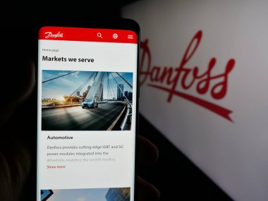 Stuttgart, Almanya - 04-24-2025: Danimarkalı HVAC şirketi Danfoss AS 'in web sitesi ile akıllı telefon sahibi kişi logonun önünde ekranda. Telefon ekranının merkezine odaklan.