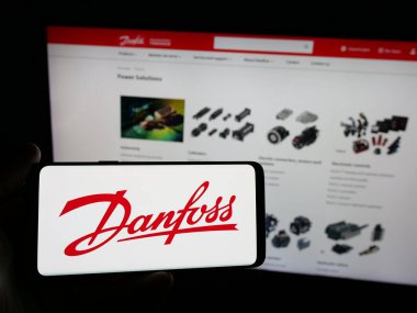 Stuttgart, Almanya - 04-24-2025: Danfoss AS adlı Danimarkalı HVAC şirketinin logosuna sahip kişi web sitesinin önünde ekranda. Telefon ekranına odaklan.