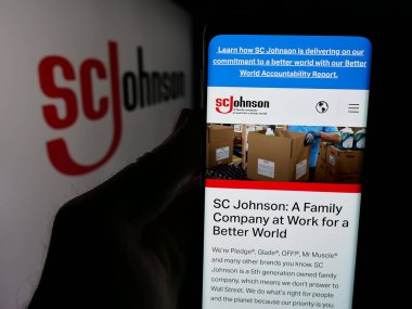 Stuttgart, Almanya - 04-24-2025: ABD 'li kimya şirketi S. C. Johnson Son Inc.' in web sitesi ile akıllı telefon sahibi kişi logonun önünde ekranda. Telefon ekranının merkezine odaklan.