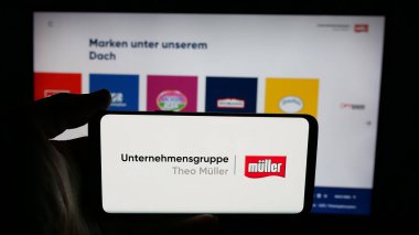 Stuttgart, Almanya - 04-24-2025: Mandıra şirketi Unternehmensgruppe Theo Mueller 'in logosunun bulunduğu cep telefonu web sayfası önünde ekranda. Telefon ekranına odaklan.