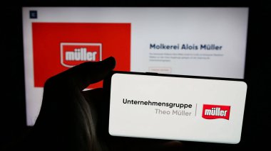 Stuttgart, Almanya - 04-24-2025: Süt ürünleri şirketi Unternehmensgruppe Theo Muller 'in logosuna sahip cep telefonu web sayfası önünde ekranda. Telefon ekranına odaklan.