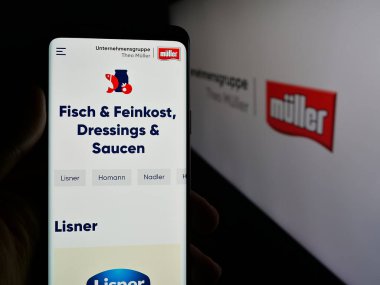 Stuttgart, Almanya - 04-24-2025: Süt ürünleri şirketi Unternehmensgruppe Theo Muller 'in web sayfası olan cep telefonu logonun önünde ekranda. Telefon ekranının merkezine odaklan.