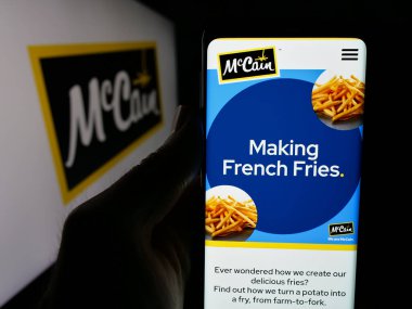 Stuttgart, Almanya - 04-24-2025: Kanadalı gıda şirketi McCain Foods Limited 'in web sitesi ile akıllı telefon sahibi kişi logonun önünde ekranda. Telefon ekranının merkezine odaklan.
