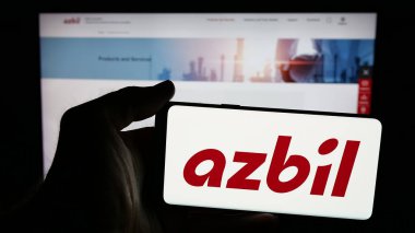 Stuttgart, Almanya - 04-25-2025: Japon otomasyon şirketi Azbil Corporation 'ın logosunun bulunduğu cep telefonu web sayfası önünde ekranda. Telefon ekranına odaklan.