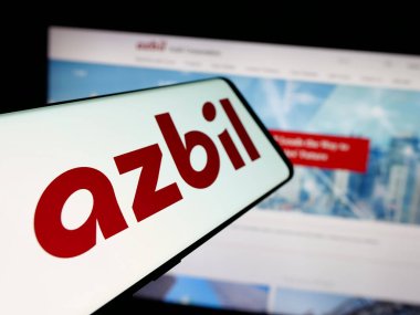 Stuttgart, Almanya - 04-25-2025: Japon otomasyon şirketi Azbil Corporation 'ın logosuna sahip akıllı telefon web sitesinin önünde ekranda. Telefon ekranının merkez soluna odaklan.