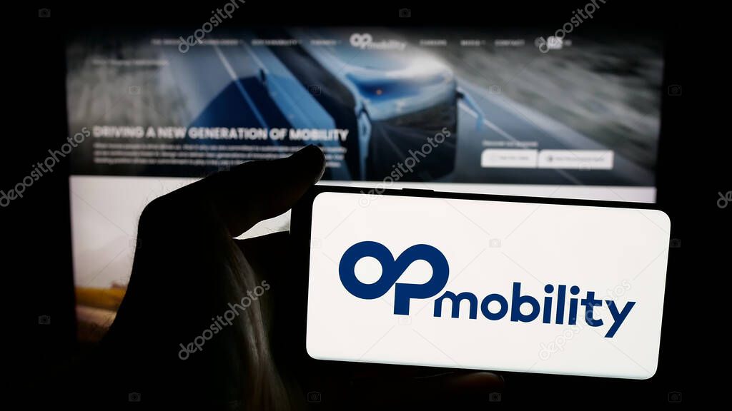 Stuttgart, Germany - 04-24-2025: Person holding mobile phone with logo of Franch automotive company OPmobility SE on screen in front of web page. Focus on phone display.
