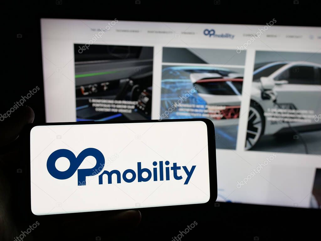Stuttgart, Germany - 04-24-2025: Person holding smartphone with logo of Franch automotive company OPmobility SE on screen in front of website. Focus on phone display.