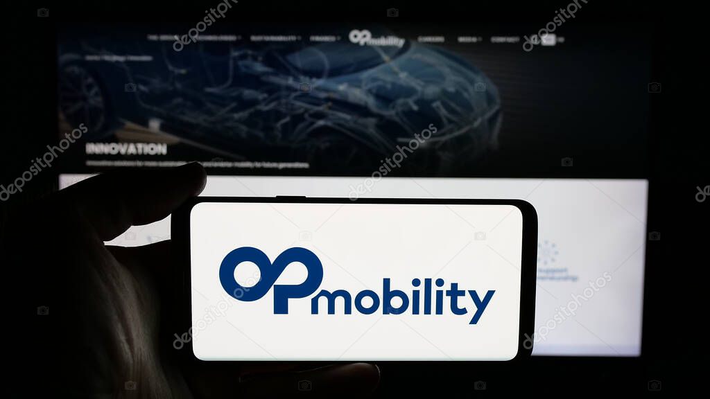 Stuttgart, Germany - 04-24-2025: Person holding cellphone with logo of Franch automotive company OPmobility SE on screen in front of webpage. Focus on phone display.