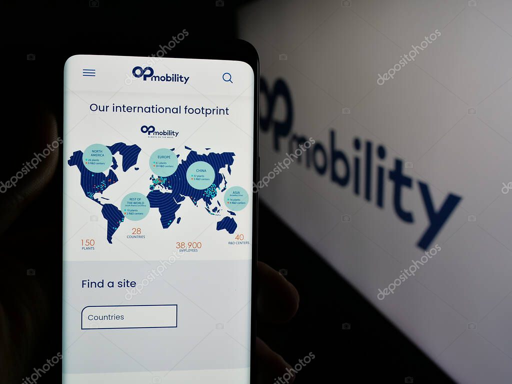 Stuttgart, Germany - 04-24-2025: Person holding cellphone with web page of Franch automotive company OPmobility SE on screen in front of logo. Focus on center of phone display.