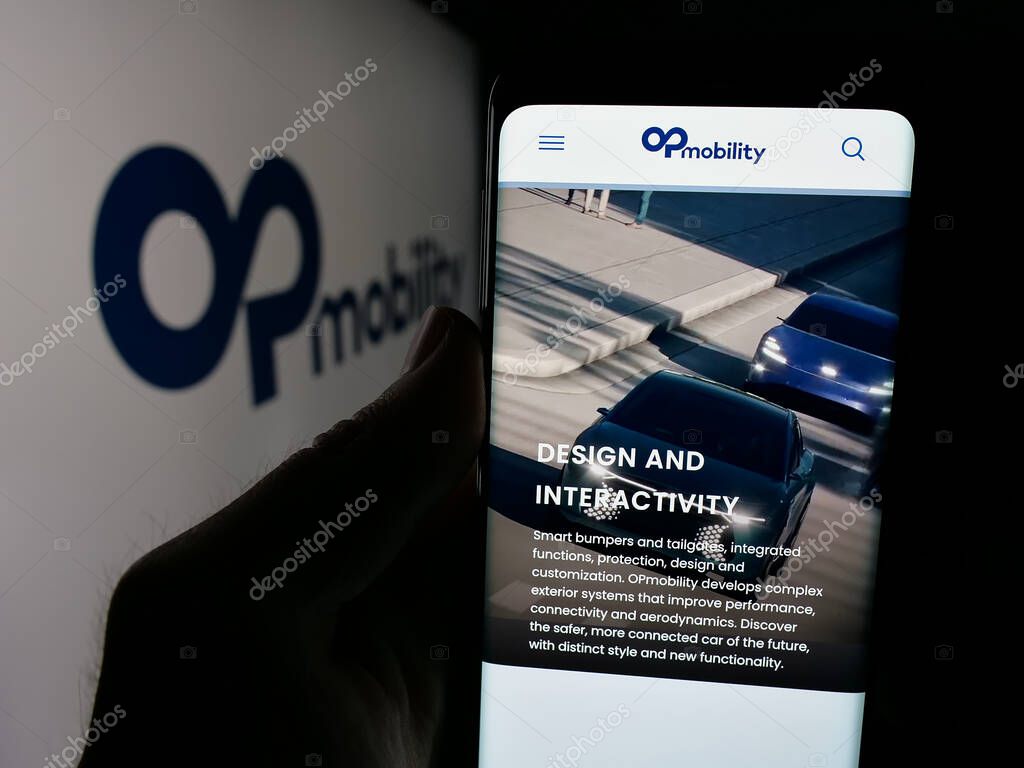 Stuttgart, Germany - 04-24-2025: Person holding smartphone with website of Franch automotive company OPmobility SE on screen in front of logo. Focus on center of phone display.