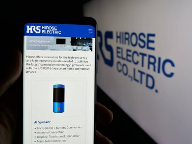 Stuttgart, Almanya - 04-25-2025: Elektronik şirketi Hirose Electric Co. Ltd. nin web sitesi ile akıllı telefon sahibi kişi logonun önünde ekranda. Telefon ekranının merkezine odaklan.