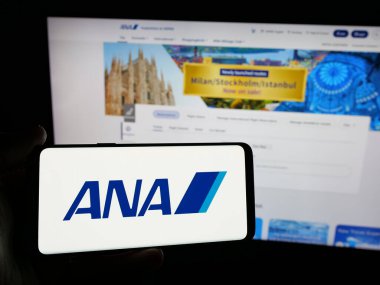 Stuttgart, Almanya - 04-25-2025: Web sitesinin önünde All Nippon Airways Co. Ltd. (ANA) adlı şirketin logosuna sahip kişi ekranda. Telefon ekranına odaklan.