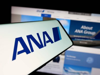 Stuttgart, Almanya - 04-25-2025: Web sitesi önünde All Nippon Airways Co. Ltd. (ANA) şirketinin logosuna sahip akıllı telefon. Telefon ekranının merkez sağına odaklan.